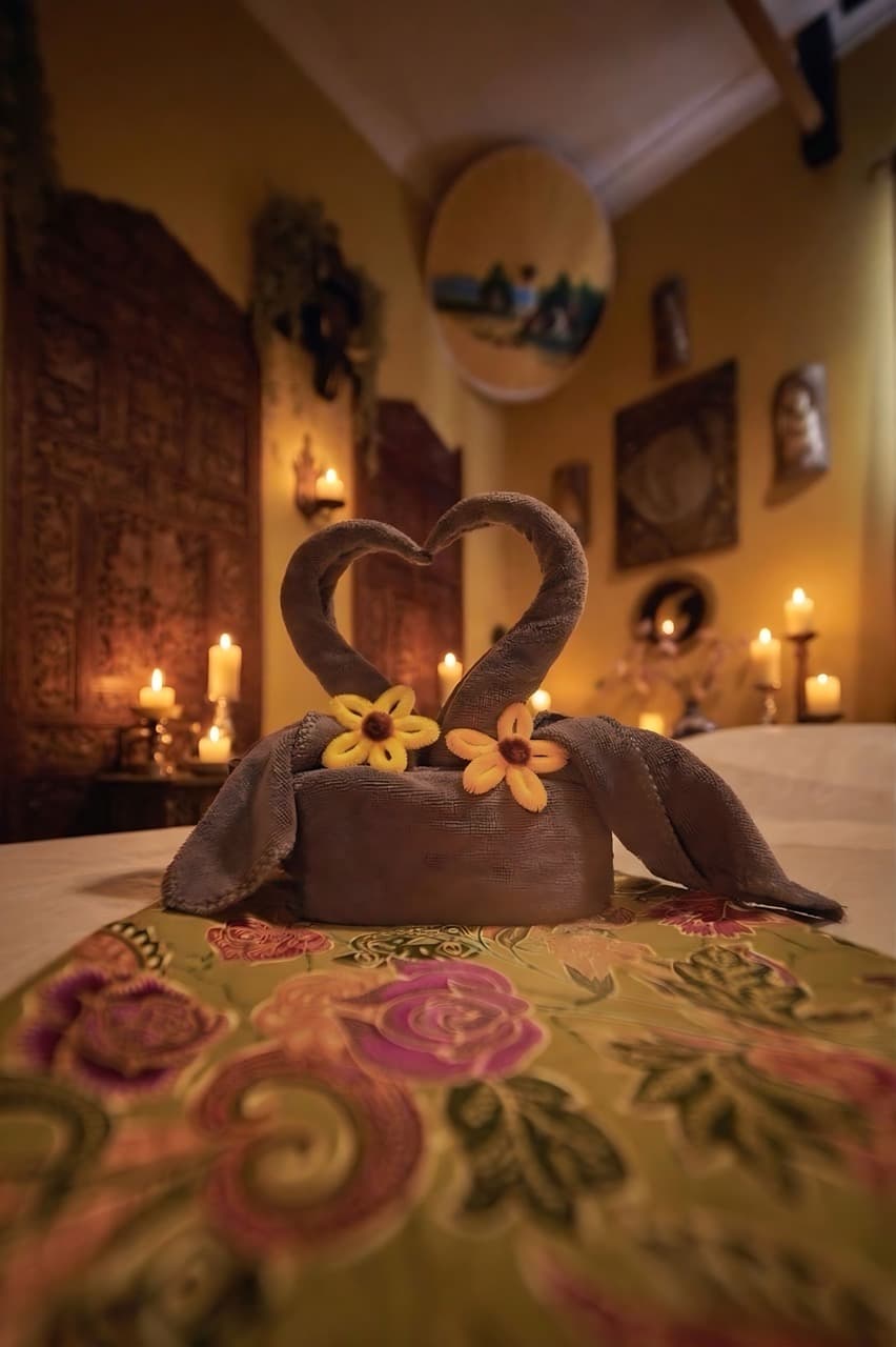 Towel swan heart decoration in a warmly lit spa setting