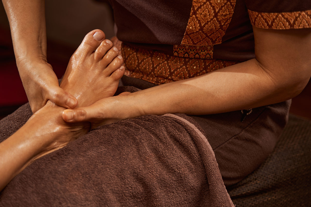 Two hands massaging a foot